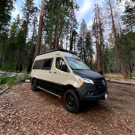 Experience nature with this rugged Winnebago Revel Sprinter van rv rental, parked in a scenic forest.