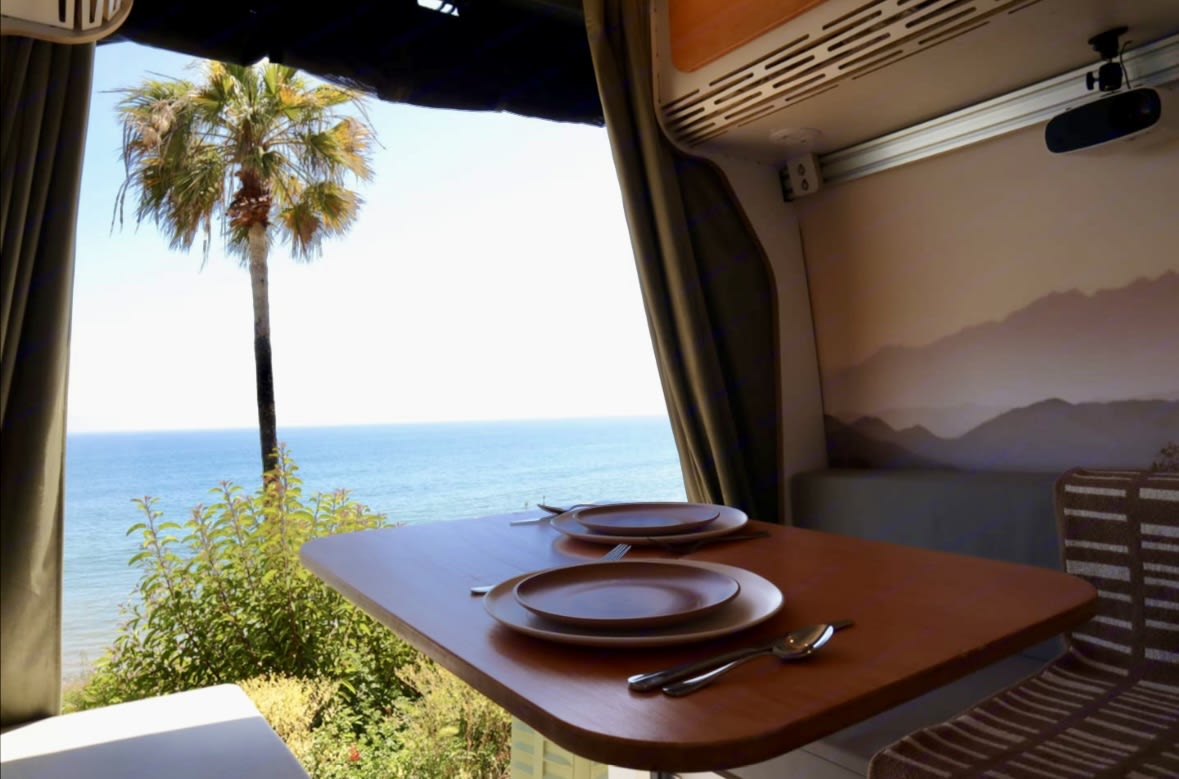  and kitchen.|Cozy RV rental bed with ocean & palm tree views. Features succulent pillows — photo 4