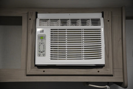 White built-in AC unit inside an RV rental, with a digital display set to 62 degrees for comfort.
