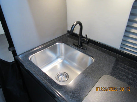  displaying HDMI2 at 1080p 60Hz.|RV rental interior featuring a modern kitchenette with microwave
