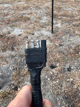 A close-up of a 4-pin trailer electrical connector, crucial for RV rental towing lights and basic functions.
