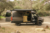 Custom Sprinter camper van with open doors and extended awning for rv rental, ready for your next adventure.
