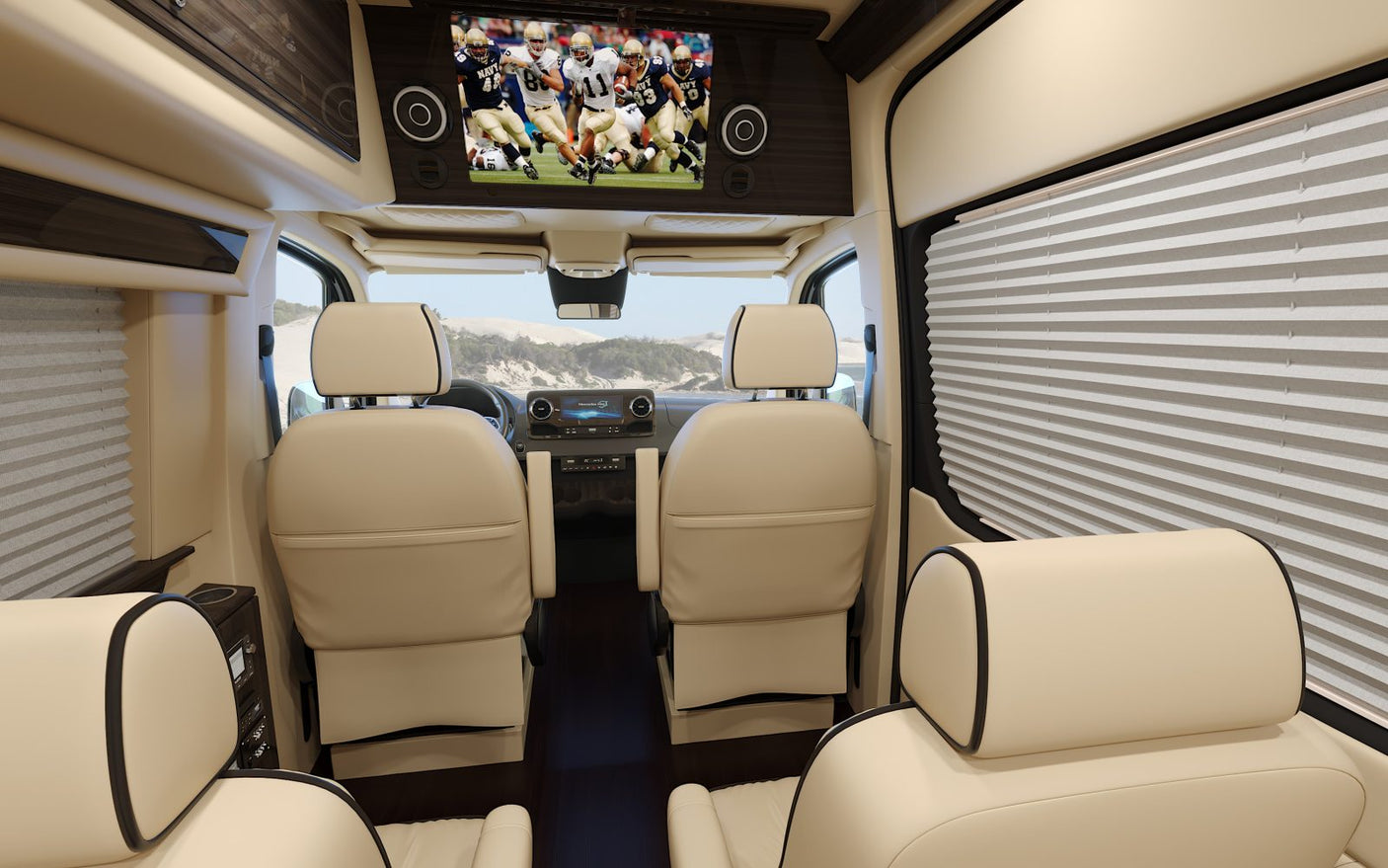 Luxurious rv rental interior: cream leather seats, a large TV playing football, and pleated window blinds for comfort.