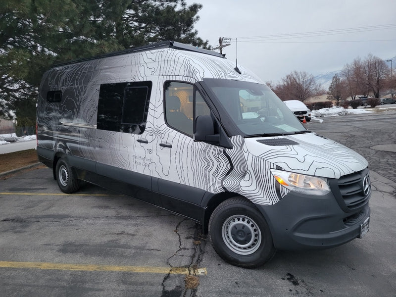 This Mercedes-Benz Sprinter rv rental features a unique topographic map wrap, ideal for travel & outdoor adventures. — photo 5