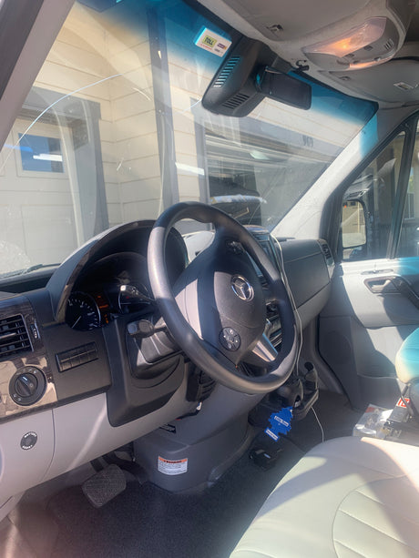 Interior of an RV rental's driver's side, showing a Mercedes-Benz steering wheel, dashboard, and a visible windshield crack.