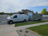 White cargo van and utility trailer parked. Versatile setup for hauling, a practical alternative to an RV rental.