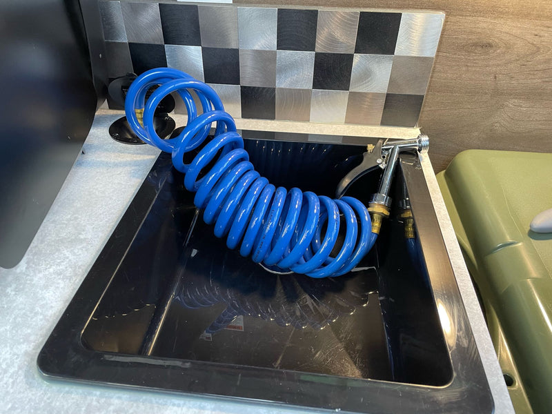  and coiled cable for utilities. Compact living space interior.|Cozy RV rental interior featuring a comfortable bed — photo 10