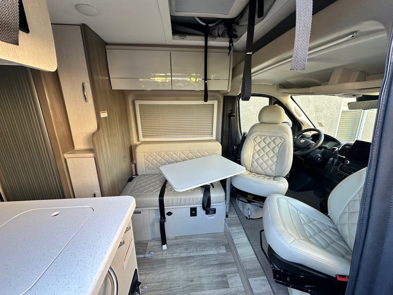 and organized storage bay below.|Detailed RV rental interior showcasing swivel front seats — photo 12