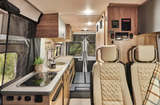 Explore a spacious rv rental! This modern camper van features a functional kitchen, comfortable seating, and rear views.