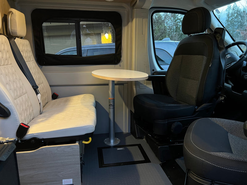 Inside an RV rental: versatile camper van interior with comfy seats, a functional table, and a view, ready for adventure. — photo 13
