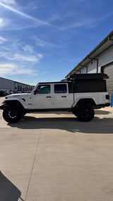 White Jeep Gladiator with overland camper, rooftop tent. Ideal off-road rv rental adventure.