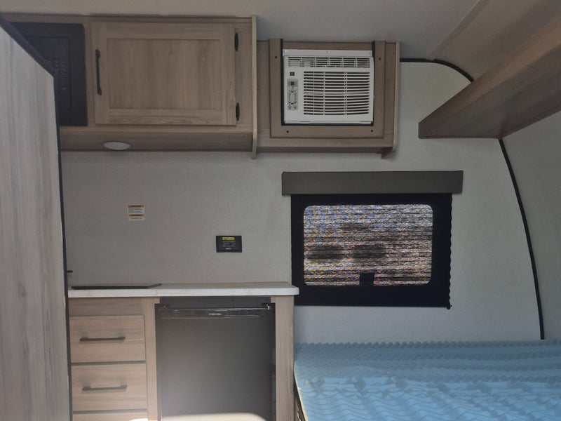  and cabinet.|Compact RV rental interior: kitchen with fridge — photo 4