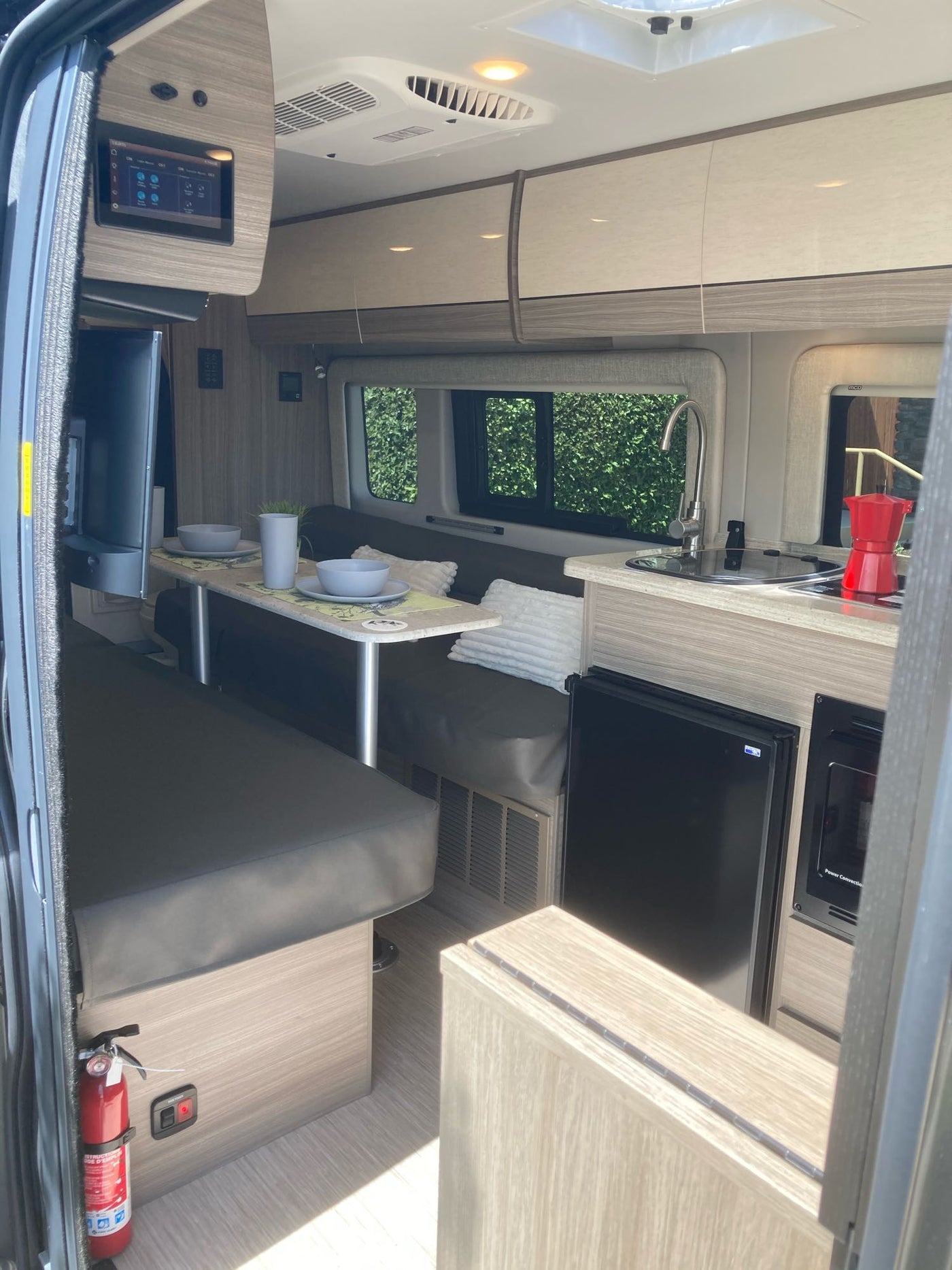 Modern RV rental interior: kitchen, dinette, TV, and controls. Perfect for mobile living adventures. — photo 14