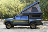 Green Toyota Tacoma TRD 4x4 truck camper with Alu-Cab rooftop tent, ideal for your next RV rental adventure.