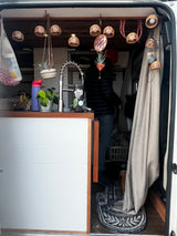 Cozy RV rental interior: a charming living space with kitchen, unique decor, and a person inside.
