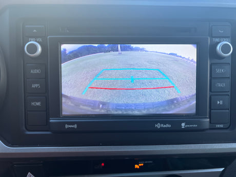 A modern car stereo and display in an RV rental, showing the rear camera view with blue and red guidelines.