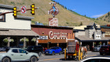Jackson Hole's iconic Million Dollar Cowboy Bar, horse carriage, and cars on a sunny day. A must-see on your RV rental road trip.