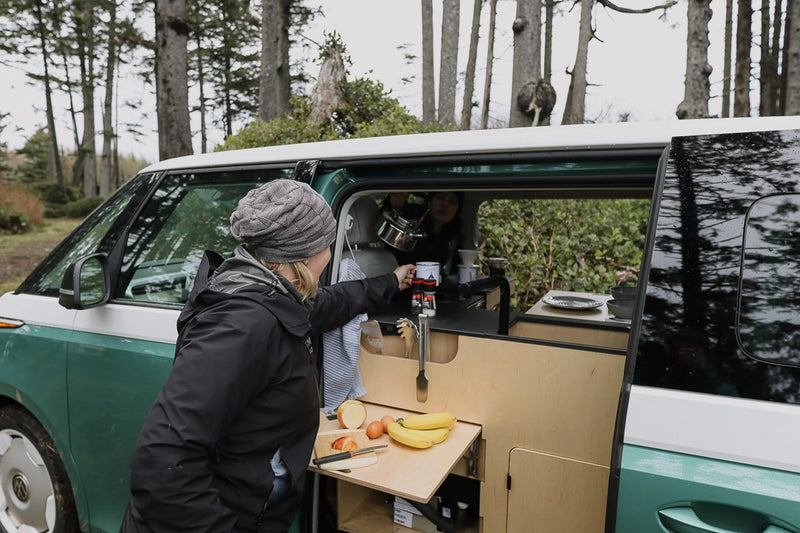  and expansive windows offer nature views for your next mobile adventure.|Happy woman making coffee in a modern RV rental camper van — photo 2