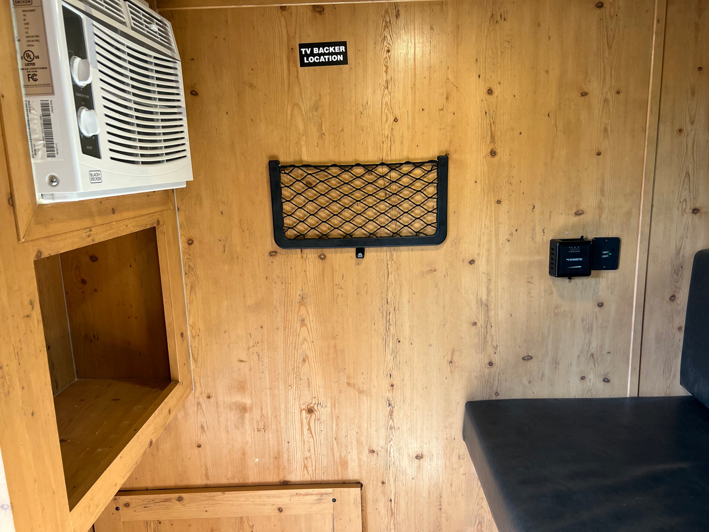 RV rental interior showing a Black+Decker AC unit, "TV Backer" area, storage net, Dometic control, and USB port.