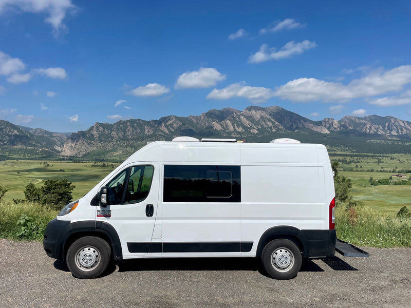  overlooking a vibrant green valley and majestic mountains.|White camper van — photo 2