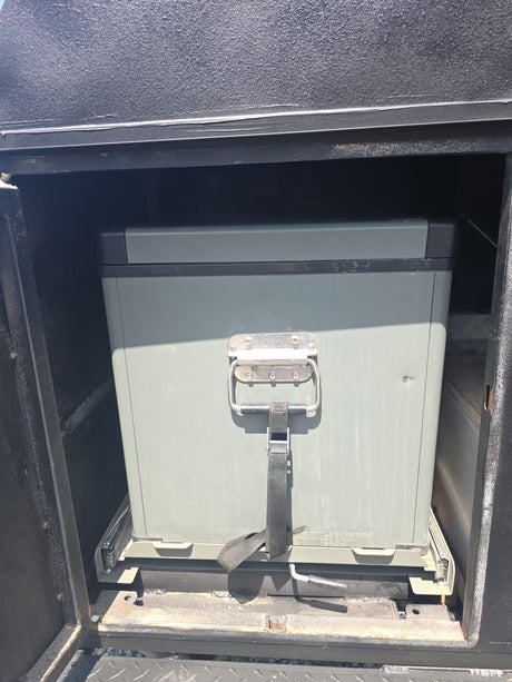 RV rental ready: A heavy-duty gray storage box on a pull-out slide system within a vehicle compartment, ideal for gear.