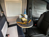 Cozy RV rental dining space: enjoy sushi on a small table, with comfy seating and window shades for a relaxing travel meal.