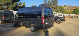 Two Ram ProMaster Tellaro camper vans, possibly rv rental units, are parked in a sunny RV park.