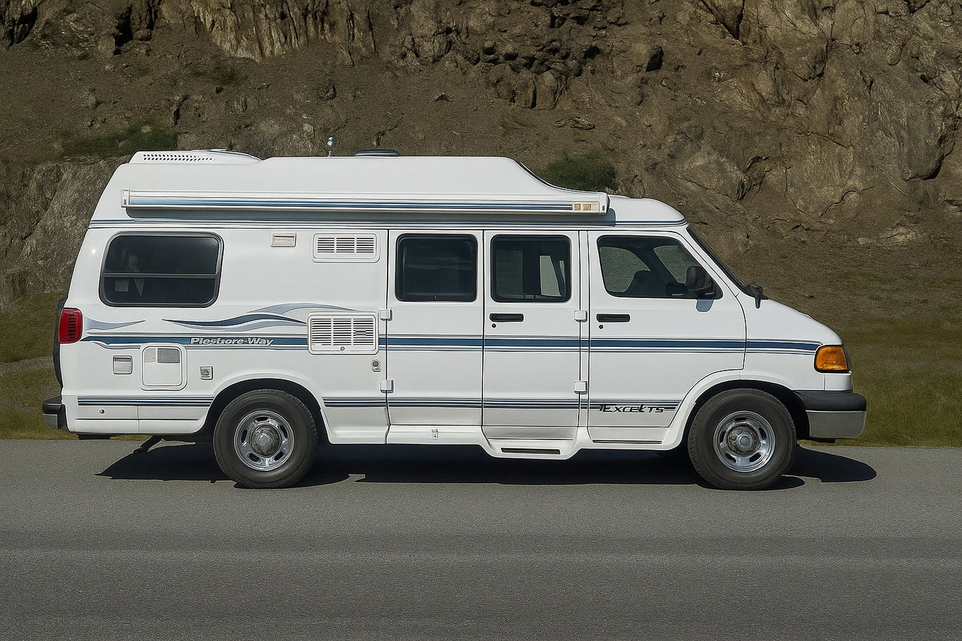 White Pleasure-Way Excel TS RV rental parked by a rocky hillside on asphalt. — photo 7