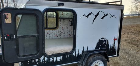 Cozy RV rental camper: custom bear and mountain exterior, warm interior with birch tree & bird wallpaper. Perfect for outdoor adventure.