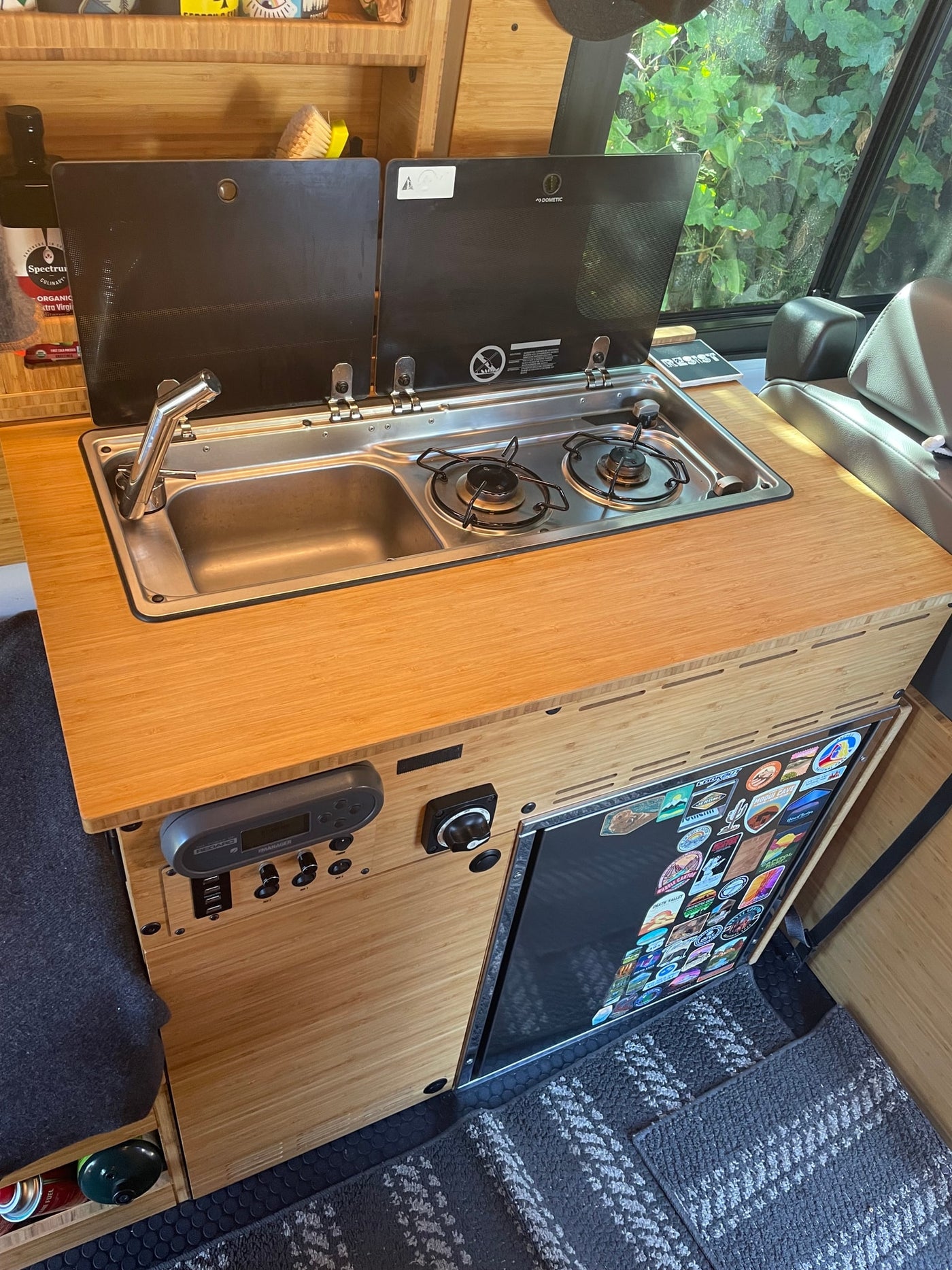 RV rental bamboo kitchen with integrated Dometic sink/stove, Redarc controls, and a refrigerator, ideal for travel. — photo 6