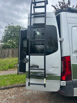 Rear view of a white Mercedes Sprinter RV rental, with a ladder and open door revealing the interior. Ready for adventure!