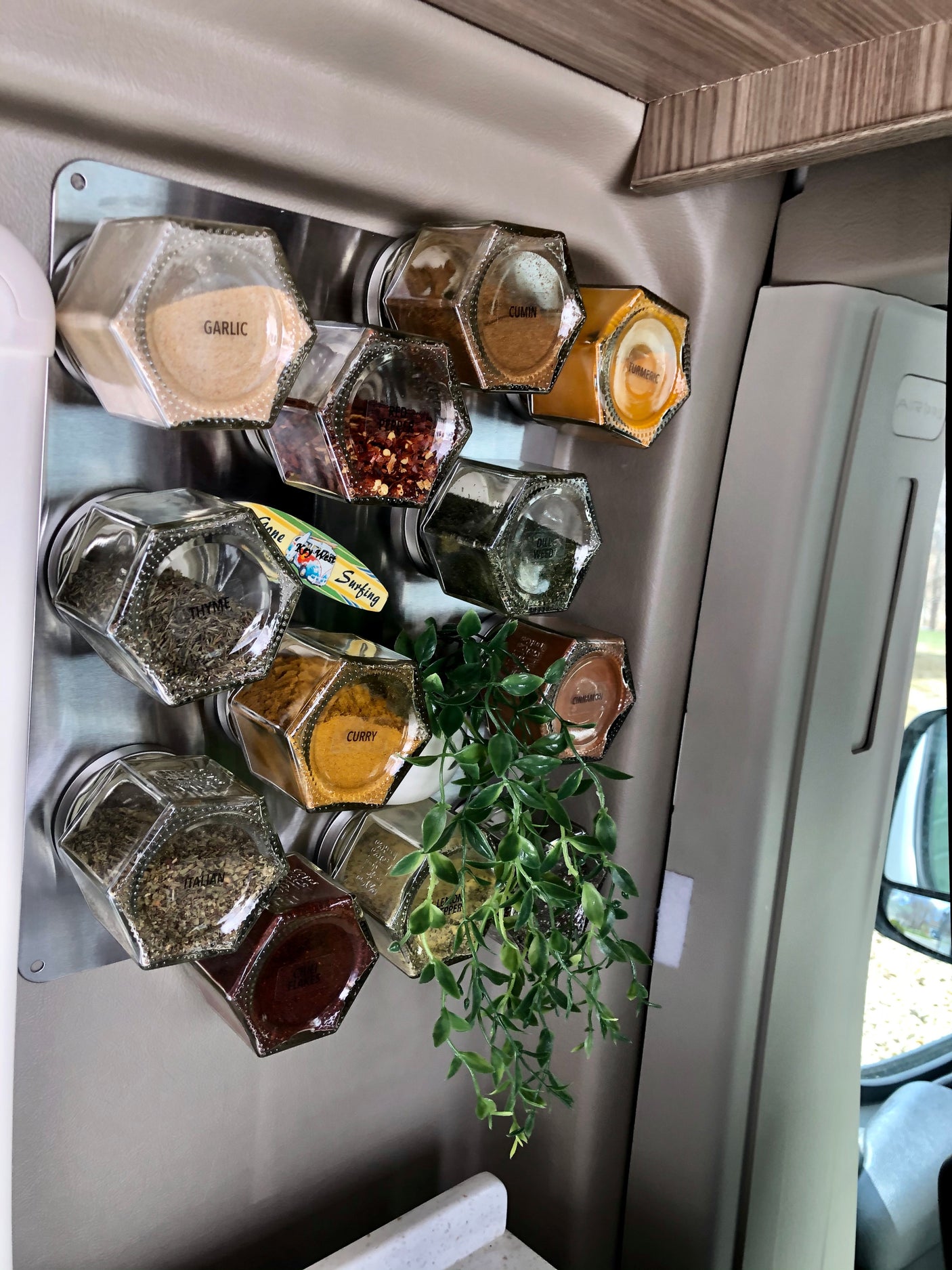 This RV rental features a clever magnetic spice rack mounted on the wall, perfect for organized kitchen essentials on the go.