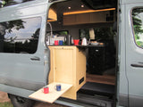 This RV rental camper van features a compact kitchen inside & a convenient fold-out outdoor table for coffee time.