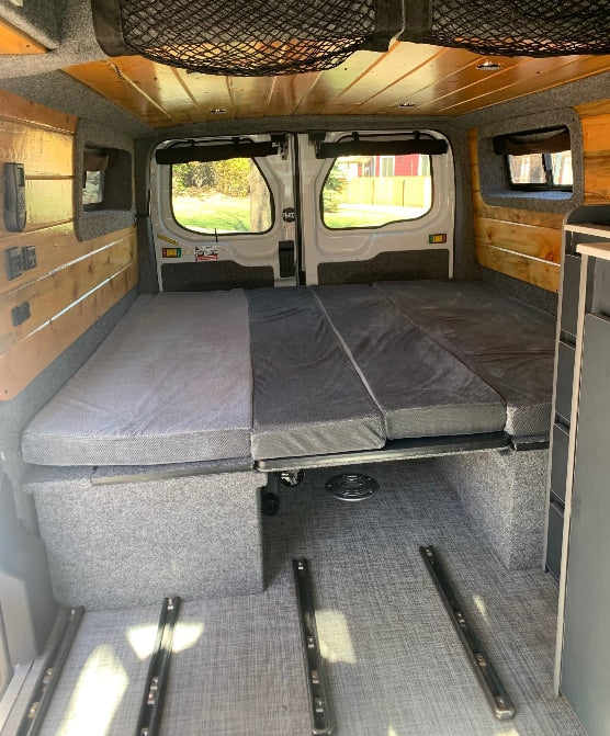 RV rental ready: This camper van features a modular bed/seating area, under-bed storage, and wood-paneled interior.