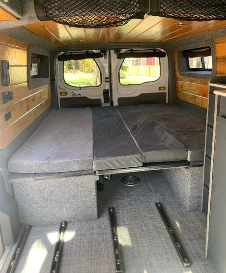 RV rental ready: This camper van features a modular bed/seating area, under-bed storage, and wood-paneled interior.