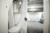 Experience an **rv rental** with a functional interior, featuring a compact bathroom (toilet, shower) and a comfy bedroom. Efficient design.