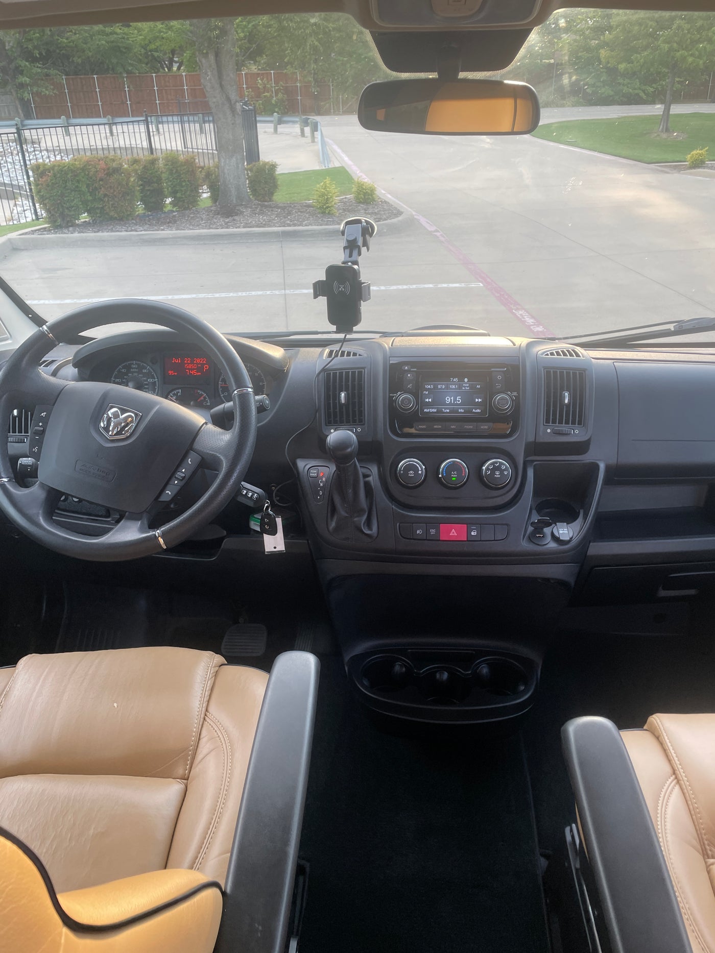 RV rental driver's seat view: Dashboard, steering wheel, and a sunny parking lot outside. — photo 7