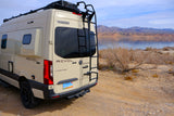 Winnebago Revel 4x4 camper van (rv rental) by a desert lake with mountains, ready for adventures.