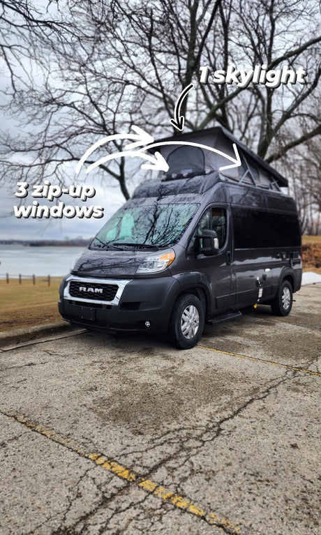 This dark gray RV rental features a pop-top with 3 zip-up windows and 1 skylight, perfect for van life adventures.