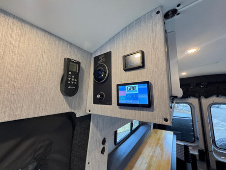 Modern **RV rental** interior showing mounted MaxxAir fan, climate control, and Grit Overland power/tank monitors.