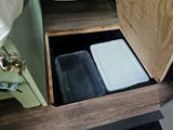 RV rental hidden storage: A convenient floor compartment contains clear and white plastic bins.