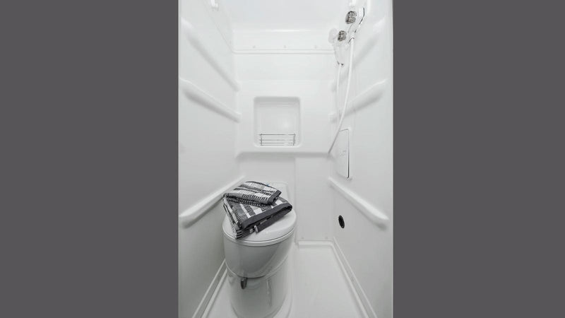 Compact RV rental wet bath with toilet and shower, featuring towels on the toilet. Ideal for camper travel. — photo 14
