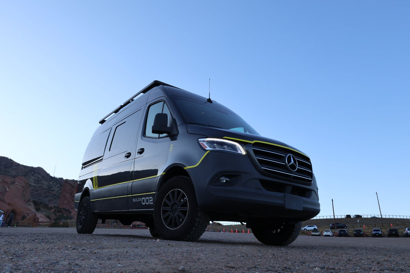 This sleek black Mercedes Sprinter rv rental van, "BUILD# 002", is parked at Red Rocks, ready for your next adventure.