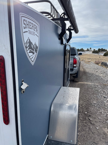 Off-road ready Sherpa trailer with awning & truck. An ideal RV rental for rugged outdoor adventures on dirt roads.