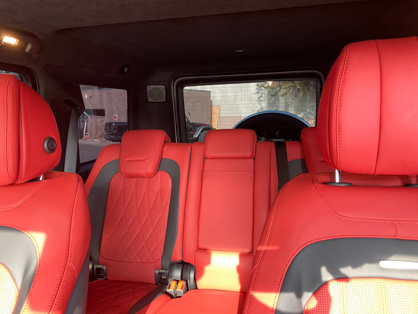 Inside a luxury vehicle: striking red leather rear seats, offering premium comfort for your next RV rental adventure. — photo 4