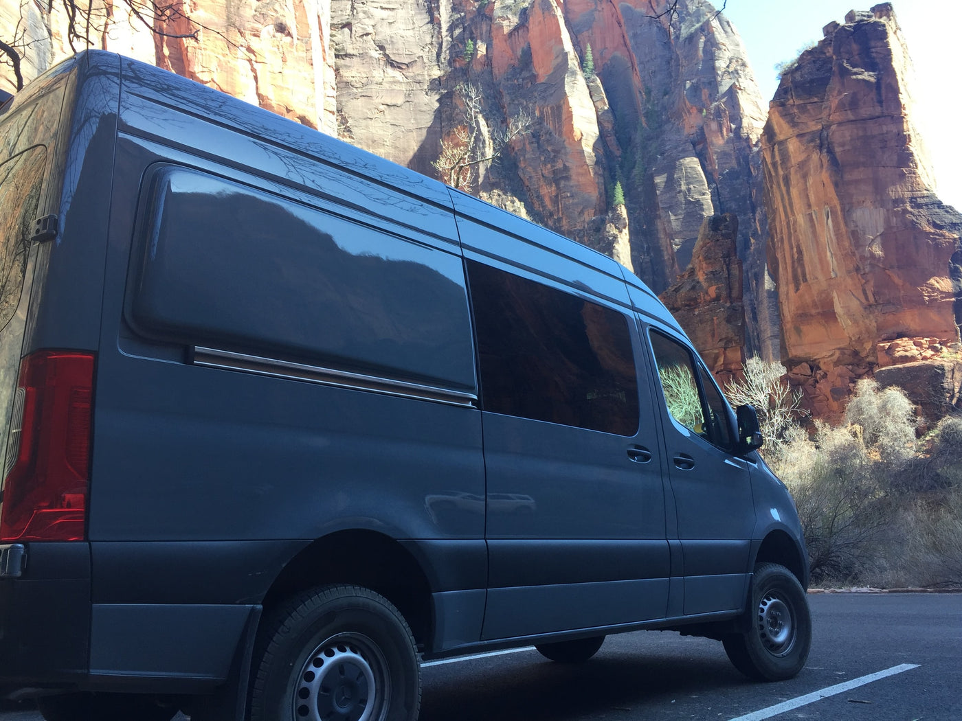 Dark gray RV rental van parked by towering red rock canyon walls. Perfect for a national park adventure. — photo 5
