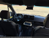 Interior view of an RV rental showing the dashboard, steering wheel, front seats, and a convenient tray table.