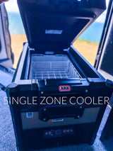 Inside an RV rental, an open ARB single zone portable fridge/freezer, perfect for keeping food cool on your travels.