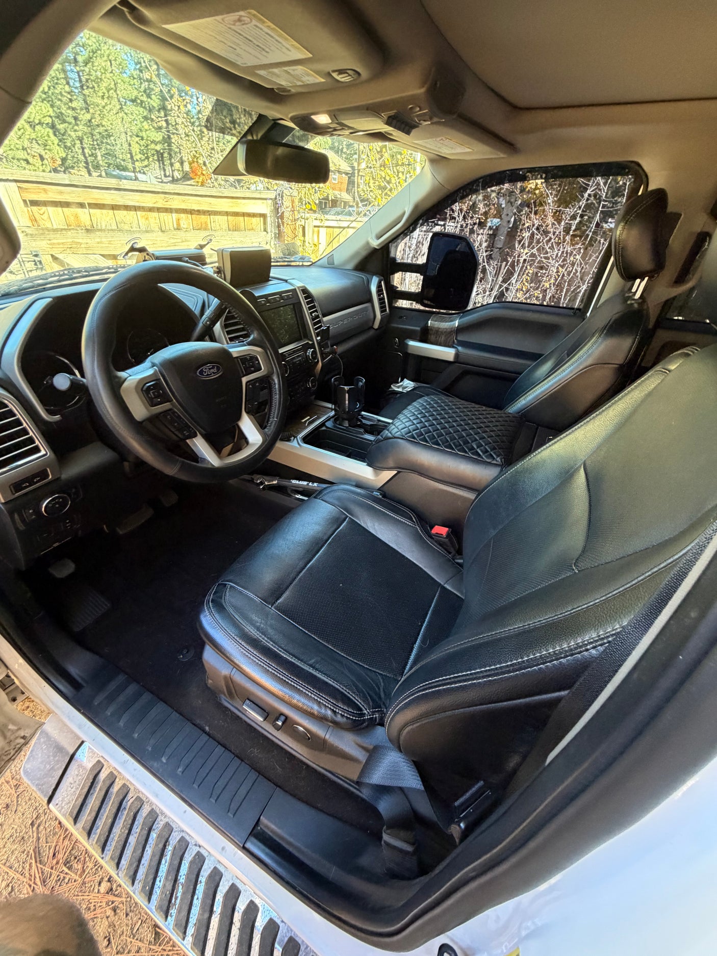 View inside a Ford F-Series truck, ideal for an RV rental. Features black leather seats, dashboard, and steering wheel.