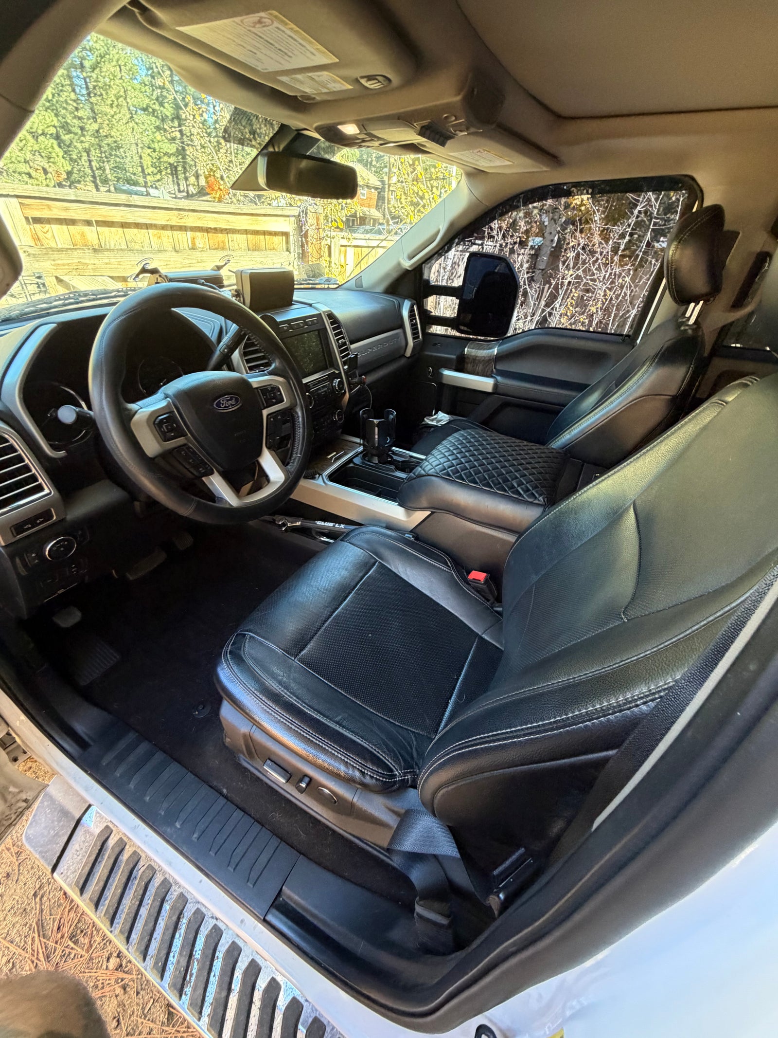 View inside a Ford F-Series truck, ideal for an RV rental. Features black leather seats, dashboard, and steering wheel.